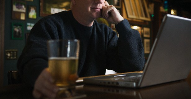 Man Using Laptop in Bar